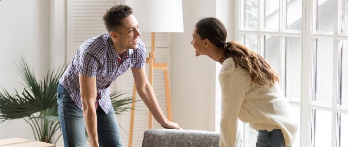 Couple moving furniture in apartment