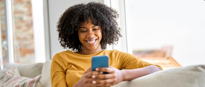 Woman smiling while looking at her phone